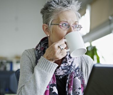 Businesswoman sitting in office drinking coffee