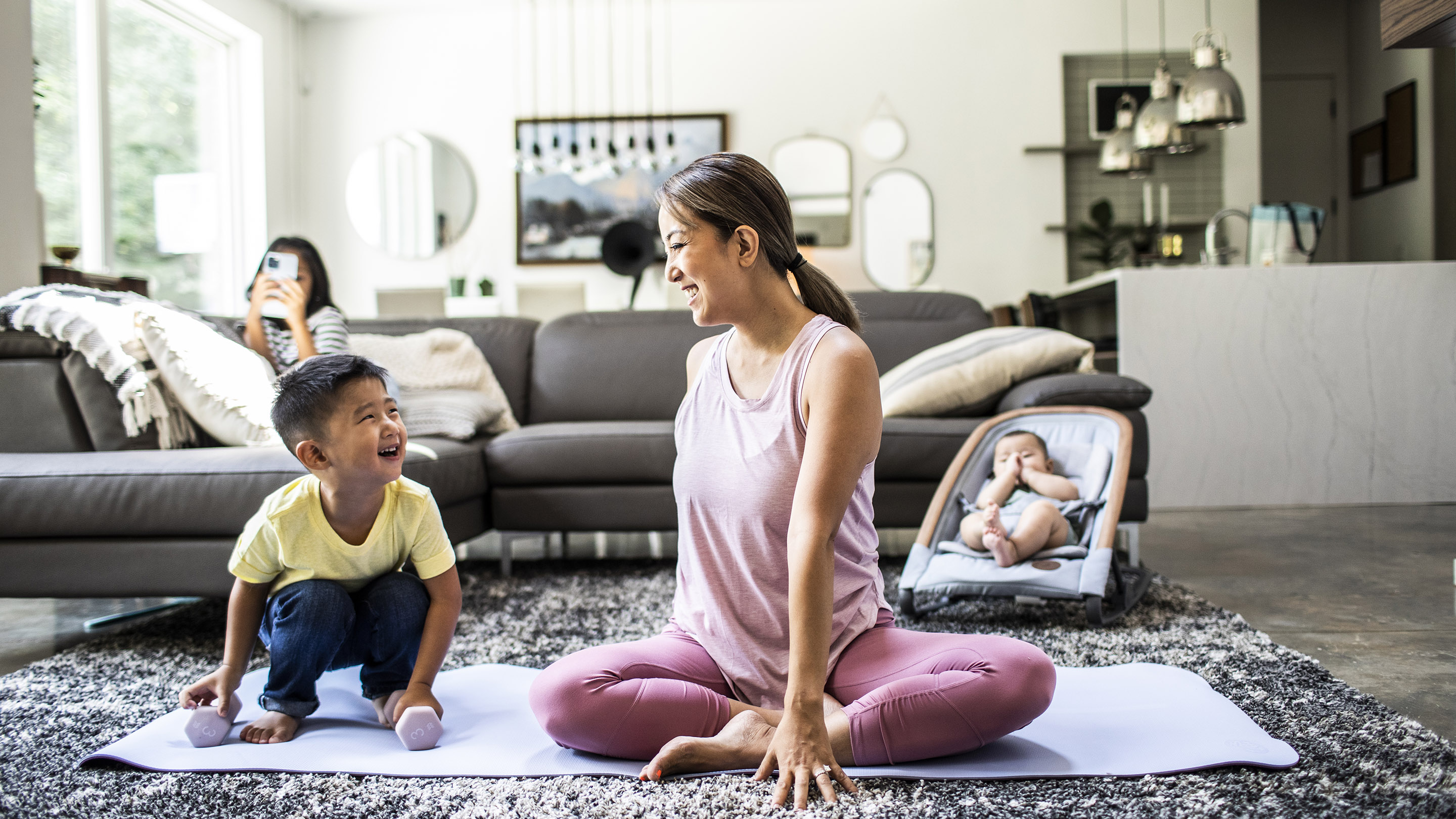 New Mother Does Yoga On A Mat While Nursing Child by Stocksy Contributor  McKinsey Jordan - Stocksy