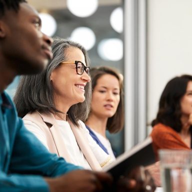 Smiling businesswoman looking away with colleagues