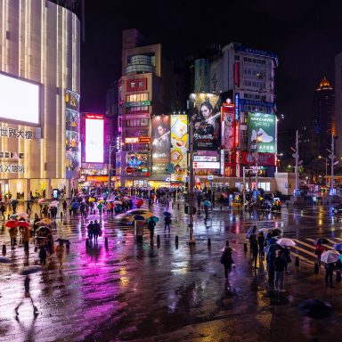 People By Illuminated Buildings In City At Night