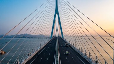 Aerial photography of cross sea highway at sunset