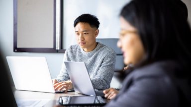 A pair of Asian colleagues working together on a project.