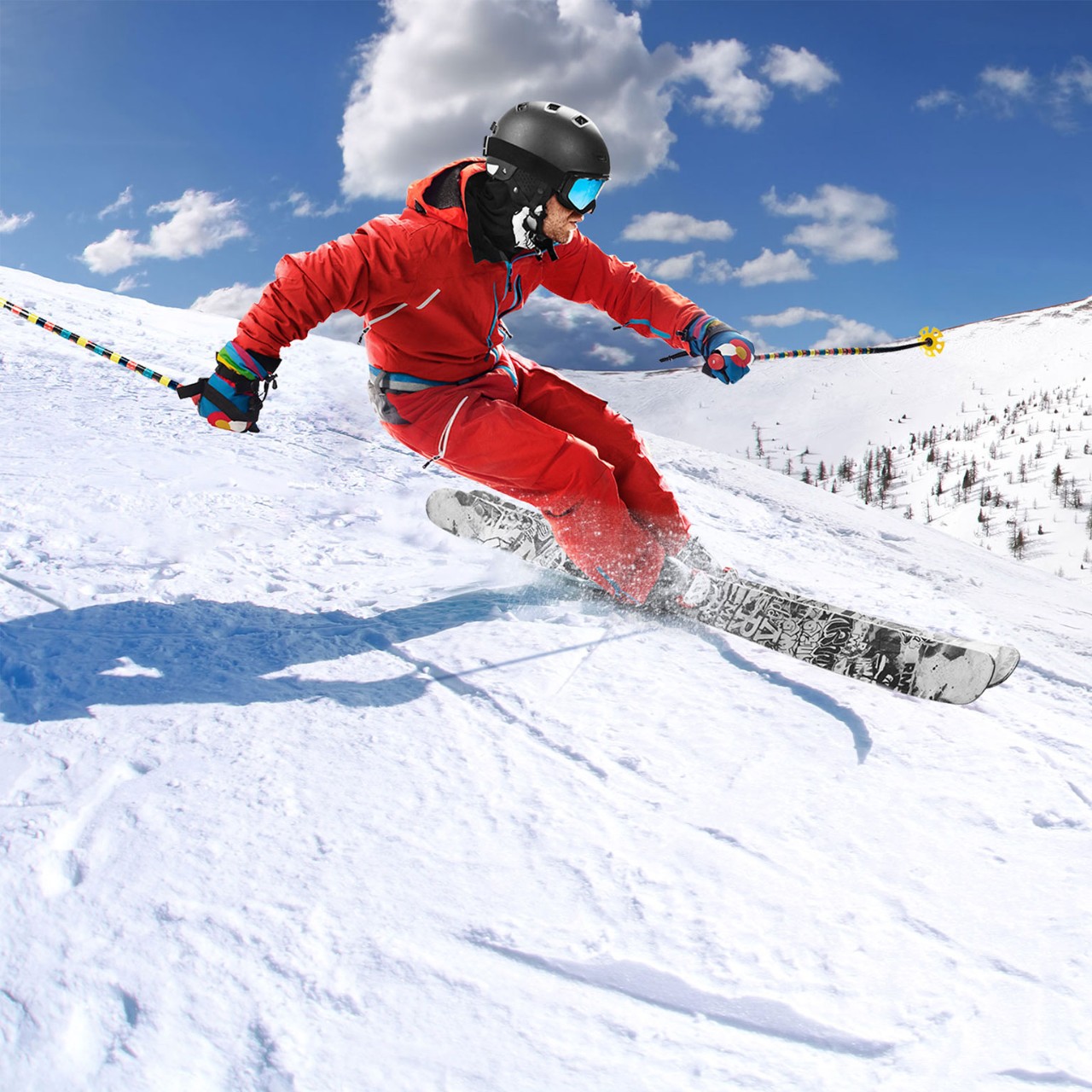 Mand står på ski ned ad bakke