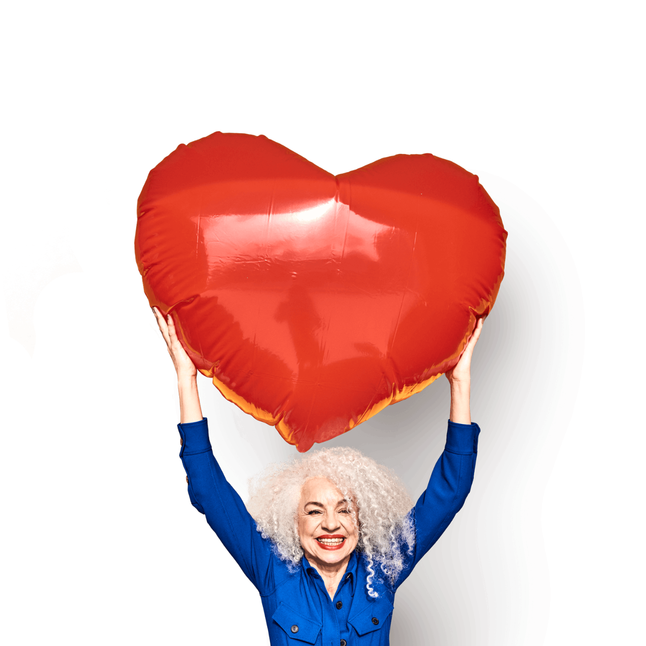 Colourful studio portrait of a senior woman holding a heart balloon
