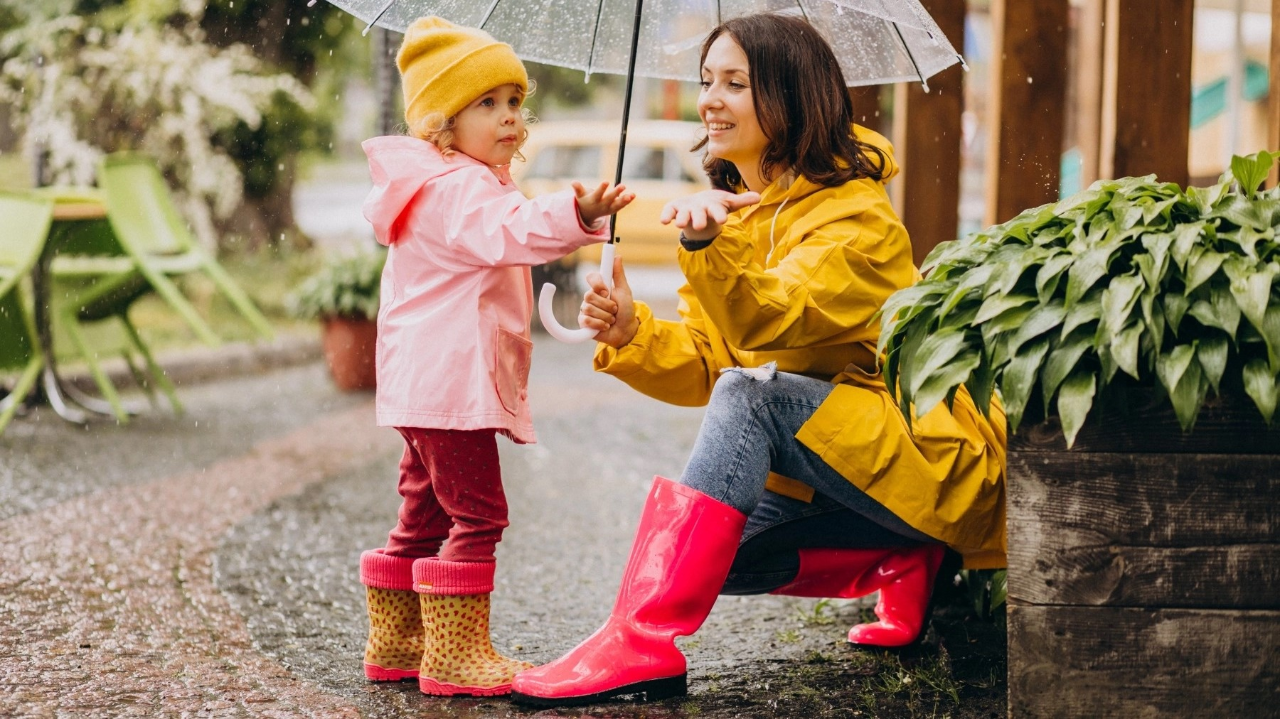 girl and woman under umbrella catching rain