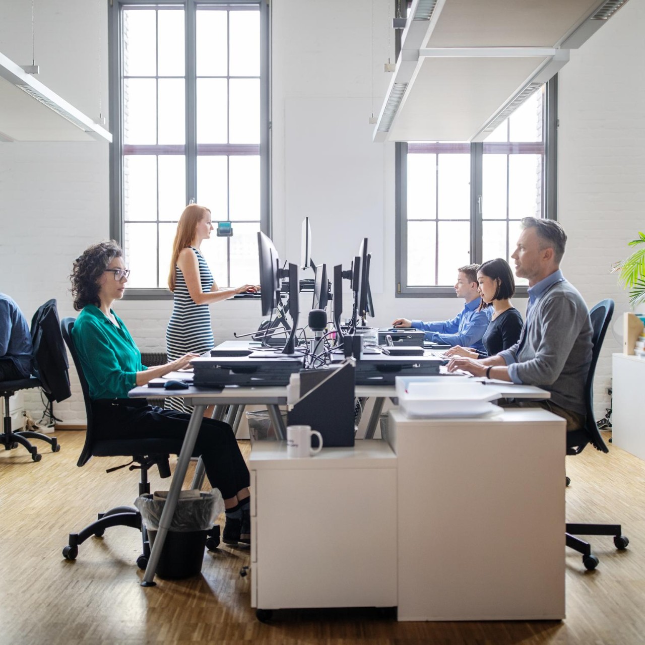 Business people at their desks in a busy, open plan office