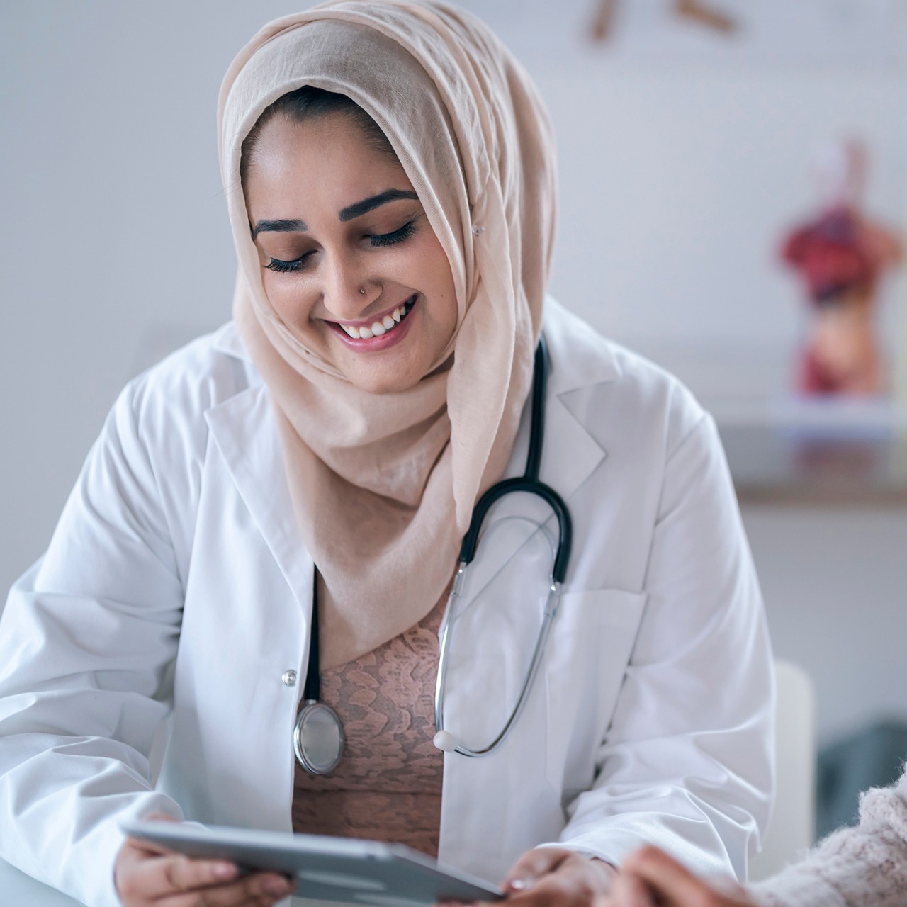 A female Muslim doctor is consulting a patient. 