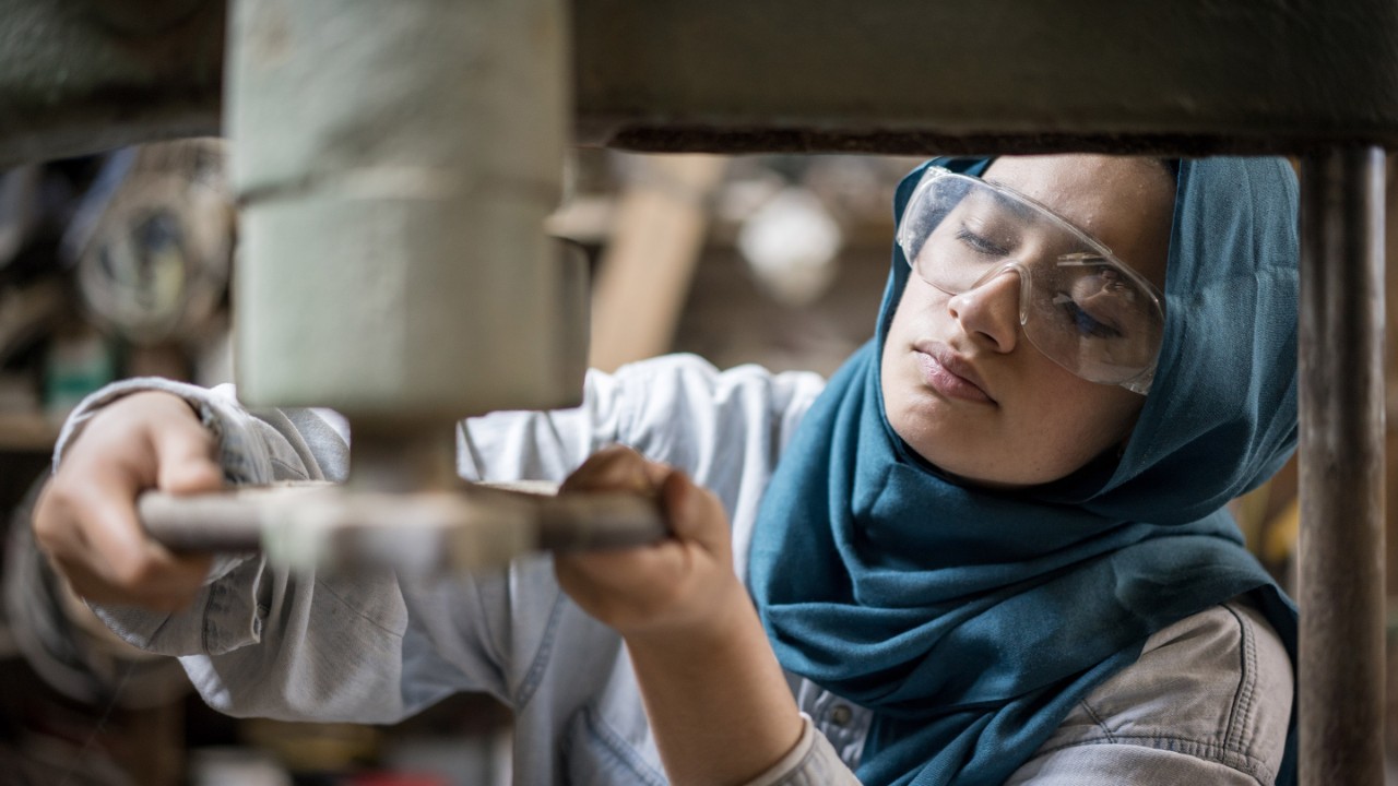 イスラム教徒の少女が小さな大工工場で働いています。